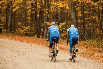 Men biking down road in the fall