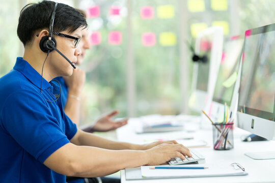 Handsome Man In Blue Shirt Customer Service Operator Working With Computer And Headsets In The Office, Customer Service Assistant Working, Technical Support Operator