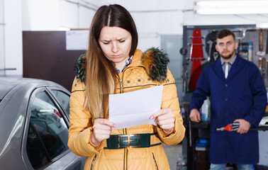 Female is dissatisfied of tire winter replacement of her car in workshop.