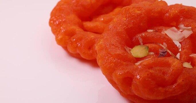 Deep fried all purpose flour batter dipped in sugar syrup sweet dessert red orange Jalebi jilapi Imarti on white background move slide rotate