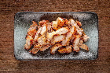 tasty slice fried pork in rectangular ceramic plate on rustic natural wood texture background, top view