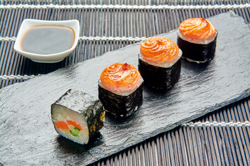 rolls with salmon teriyaki on a stone stand, Japanese cuisine