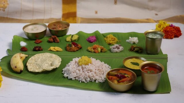 Traditional Onam sadhya 4K footage video rice and curries Sambar, Rasam,  Avial,  Pappadom Payasam on banana leaf Onam Vishu Diwali festival vegetarian food Kerala South India Sri Lanka