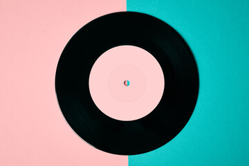 Old retro vinyl disc on colored background. Vintage toned photo