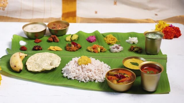 Traditional Onam sadhya 4K footage video rice and curries Sambar, Rasam,  Avial,  Pappadom Payasam on banana leaf Onam Vishu festival vegetarian food Kerala South India Sri Lanka