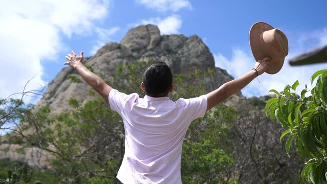 Man with arms outstretched in a mountain, relaxing in front the Pe&ntilde;a de Bernal