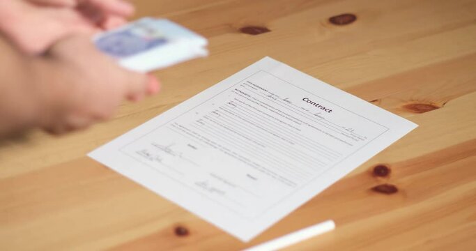 Business man count money and signing a contract, legal agreement, or paper. Man is approve documents by signing papers.