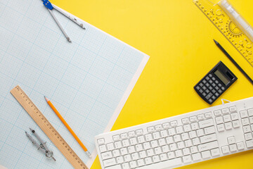 The student engineer's accessories - compass,  drawing,  pencil on  yellow background. Top View. International Students' Day