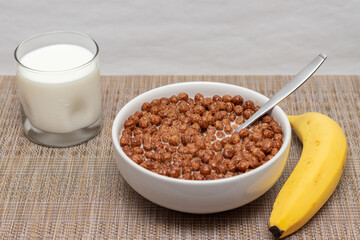 plato de cereal con vaso de leche y platano