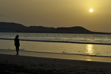 A beautiful sunset and a woman in a beach of Lanzarote