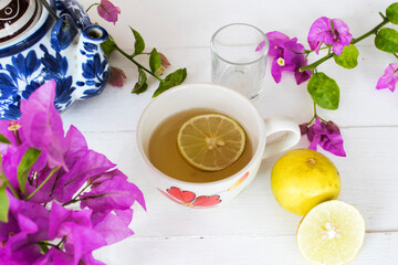 herbal healthy drinks honey lemon for health care with teapot, flowers arrangement flat lay style on background wooden white