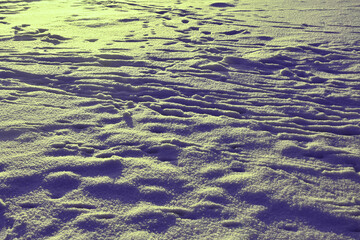 Textured background of footprints on snow in sunlight