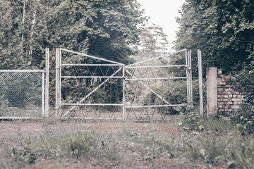 Old abandoned metal gate, on grassy forest road