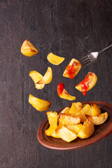 baked potatoes with tomato sauce on a plate on a dark background flying food