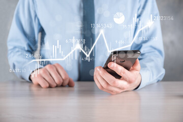Businessman in hand hold banking business finance graph and invest in stock market investment point,economic growth and investor concept.analysis virtual stock market chart,analyze by use technology