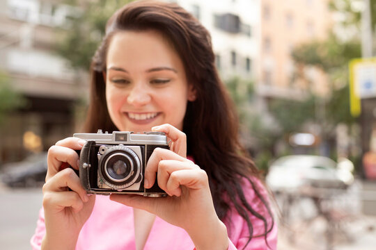 Young woman taking photo on vintage camera
