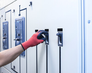 Electrical engineer tests the operation of the electric control cabinet on a regular basis for maintenance.