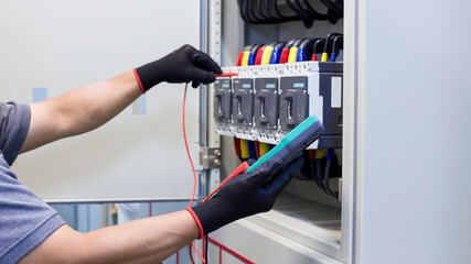 Electrical engineers check electrical control equipment.