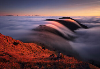 Fototapeta premium Mountain landscape above clouds at sunset in Slovakia with forest and sun