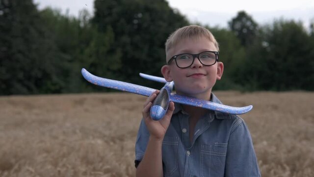 The guy is played with a toy airplane model on a wheat field.