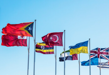 A row of different countries flags including US, UK, Ukraine on a sunny spring day in Canberra....