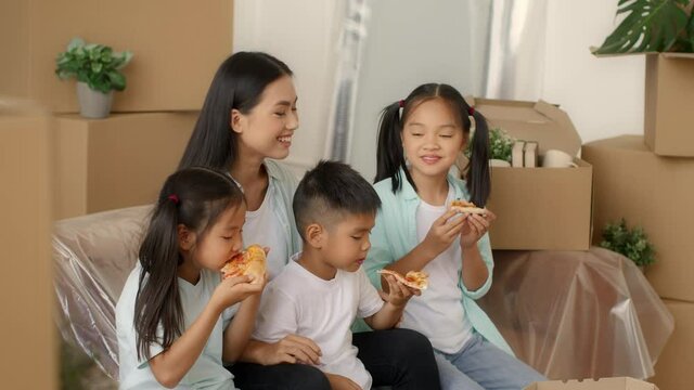 Asian Family Eating Pizza Packing Boxes Moving New House Indoor