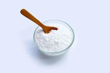Baking soda in glass bowl on white background.