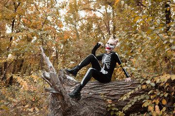 Girl with scary make-up dressed as a skeleton. Halloween, autumn holiday concept