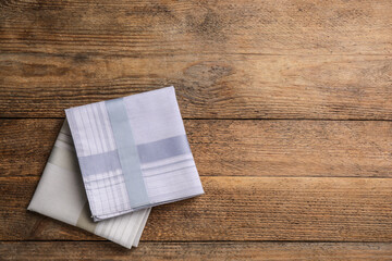 Different handkerchiefs folded on wooden table, flat lay. Space for text - obrazy, fototapety, plakaty