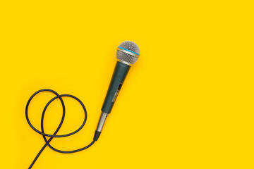Microphone on yellow background. Top view