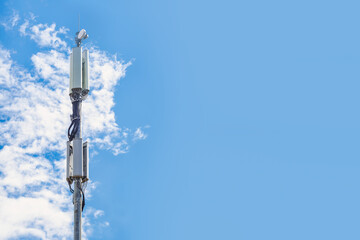 Cell tower against the blue sky. A pillar with transmitters, repeaters and antennas for mobile communications and the Internet.