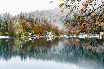 Between autumn and winter. Warm and cold reflections of snow on Lake Fusine.