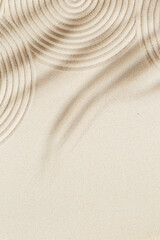 Concentration and spirituality in zen garden lines drawing in sand and shadows of palm leaves