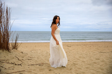 Fototapeta na wymiar Junge schöne Braut im Hochzeitskleid am Meer