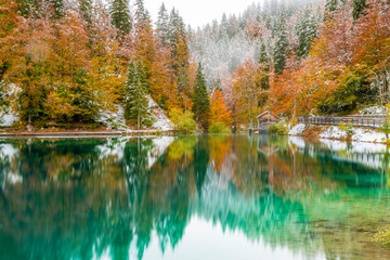 Between autumn and winter. Warm and cold reflections of snow on Lake Fusine.
