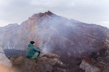 Hiker at the top of the volcano, overlooking the crater, Agung, Bali, Indonesia.