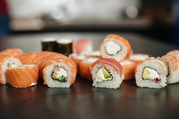 Sushi roll (Philadelphia) with salmon, smoked eel, avocado, cream cheese on black background. Sushi menu. Japanese food.