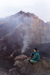 Hiker at the top of the volcano, overlooking the crater, Agung, Bali, Indonesia.