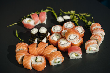 Sushi roll (Philadelphia) with salmon, smoked eel, avocado, cream cheese on black background. Sushi menu. Japanese food.