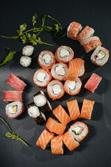 Sushi roll (Philadelphia) with salmon, smoked eel, avocado, cream cheese on black background. Sushi menu. Japanese food.