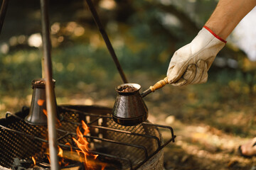 Making coffee at the stake. Make coffee or tea on the fire of nature. Tourist equipment. A bonfire close-up. Campfire and travel.
