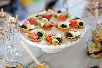 tartlets appetizers with salmon and lemon at buffet table