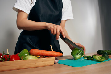 housewife in the kitchen cuts vegetables for salad healthy food