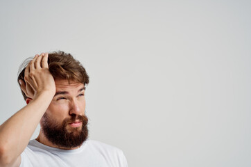 Fototapeta premium man in a white t-shirt headache migraine problems light background