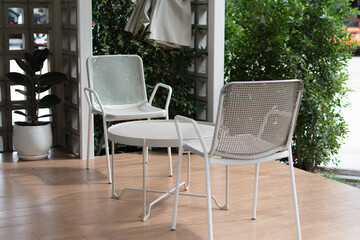 White chairs and tables are placed on the wooden floor.