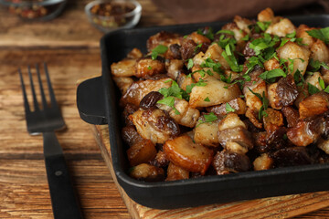 Tasty fried cracklings on wooden table, closeup. Cooked pork lard