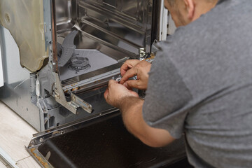 a man disassembled the dishwasher for repair