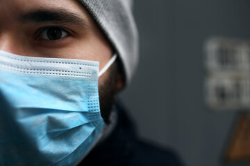 Close-up portrait outdoors of a man in a medical protective mask who is sick with a virus. Epidemic.