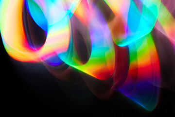 Blurred bright rainbow light. Lens or prism dynamic flare. Draving shiny spots. Dark background. Illuminated burst of multicolor light.