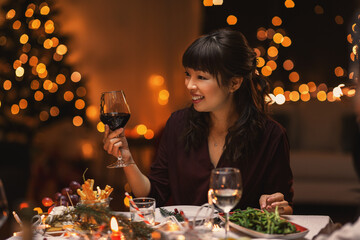 holidays, party and celebration concept - happy asian woman having christmas dinner at home and...